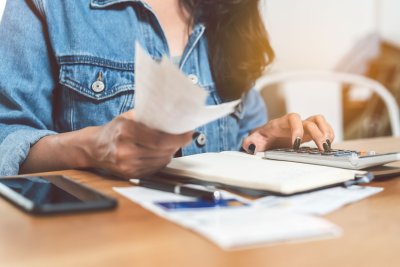 woman with bills and computer