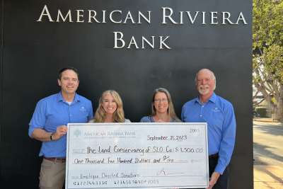 PATH employees holding up giant donation check with bankers